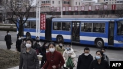 资料照片:2024年3月25日,走在朝鲜平壤凯旋门附近的一条街道上的人们。(法新社照片)
