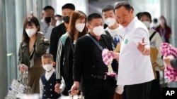 资料照片:泰国素万那普国际机场,泰国公共卫生部长阿努廷·查恩维拉库(Anutin Charnvirakul)向抵达机场的中国游客赠送花环。(2023年1月9日)