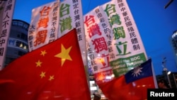 资料照 - 2016年5月14日,离台湾民选总统蔡英文就职典礼还有一个星期,支持台湾独立和主张同中国大陆和平统一的台湾民众举着各自的旗帜上街游行,表达各自的政治主张。