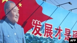 资料照:中国黑龙江哈尔滨街头邓小平呼吁发展经济的宣传画。(2003年10月2日)