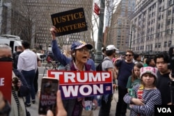 美国前总统特朗普的支持者在纽约法院外举牌支持特朗普。(2023年4月4日)