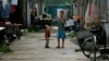 资料照:两个农民工的孩子在北京郊区一个破旧的农民工住宅区里玩耍。(2008年8月12日)