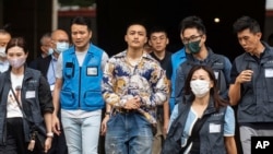 被判无罪的前民主派区议员李予信(左三)在47人案被告中被判无罪后离开香港西九龙裁判法院。(2024年5月30日)