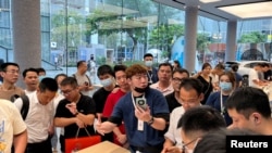 深圳一家华为商店的店员在向人们展示Mate 60系列手机。(2023年8月30日)