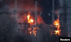 Asap dan api terlihat di sekitar saluran tegangan tinggi di lokasi serangan rudal Rusia, di tengah serangan Rusia ke Ukraina, di luar Kharkiv, Ukraina 22 Maret 2024. (REUTERS/Sofiia Gatilova)