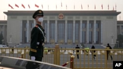 资料照:一名中国武警士兵在正在召开全国人大会议的北京人大会堂前站岗。(2023年3月7日)