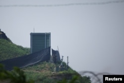 在朝韩边界非军事区附近,韩国士兵在曾经于2018年被拆除的高音喇叭位置上的军事设施旁工作。(2024年6月10日)