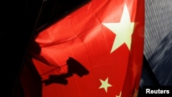 北京街头一面中国国旗后的监控摄像头。(2022年11月3日)