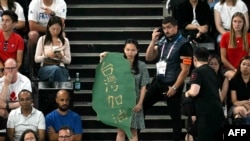 在2024巴黎奥运会羽毛球男双半决赛赛场上,一名女子手持台湾地图形状,写有“台湾加油”字样的标语。(2024年8月4日)