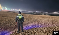 韩国海岸警卫队成员在面临日本海的江陵市海岸巡逻。(2024年1月1日)
