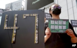资料照:香港47名因受国家安全法指控的民主活动人士的支持者在台北手举“默站声援,初选无罪”的标语举行示威活动。( 2021年3月4日)