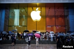 上海一家苹果专卖店外排队的人等候购买 iPhone 15 手机。(2023年6月15日)