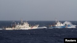 资料照:在离越南海岸大约210公里的南中国海上,从一艘越南海岸警卫队的船上看附近的中国海警船。(2014年5月14日)