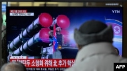 2023年2月20日,一些男子在首尔的一个火车站观看电视播放朝鲜阅兵的新闻片段。(法新社照片)