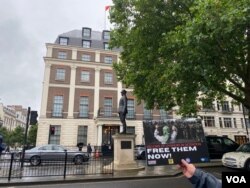 抗议者在中国大使馆们举着让维吾尔人自由的标语,呼吁国际社会关注维吾尔人的人权状况 (美国之音/李伯安)