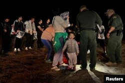 一名两岁的中国幼童跟随他的家人渡过美墨边境的格兰德河进入美国德克萨斯州,这家人正在美国边境巡逻人员那里登记以便进入移民程序。(2023年3月23日)