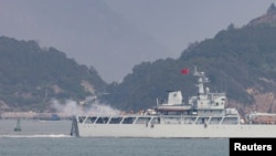 资料照:在靠近台湾金门岛的福建省福州附近海域一艘中国海军战舰在举行军演时开火。(2023年4月8日)
