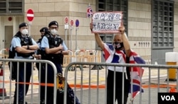 香港社运人士王婆婆2月13日连续多日到西九龙裁判法院外示威,声援民主派初选47人案各被告,她高举“立即释放所有政治犯”的标语 (美国之音/汤惠芸)