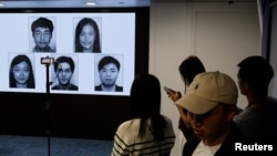 香港当局在记者会上公布被通缉的五位身处海外的香港活动人士照片。(2023年12月14日)