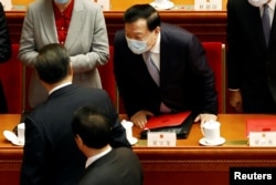 资料照:中共中央港澳办主任夏宝龙在全国人大会议上与中国领导人习近平交流。(2022年3月11日)
