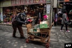 资料照:一名拾荒老人走过北京街头。(2021年3月5日)