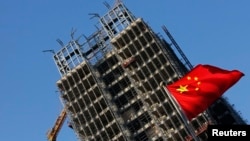 中国国旗在北京一处正在施工的楼盘前飘扬。(2013年11月4日)
