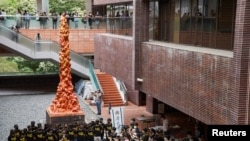 资料照片: 2021年6月4日,学生们在香港大学的“国殇之柱”前默哀一分钟,以纪念 1989年在中国香港天安门广场镇压民主示威者32周年。