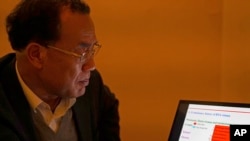 第一个发表新冠病毒序列的中国科学家张永振在他的笔记本电脑上观看演示文稿。(资料照片:2020年12月13日)