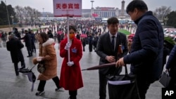 资料照片: 全国人大会议开幕式结束后,北京天泰宾馆工作人员举牌接人大代表回宾馆(2024年3月5日)