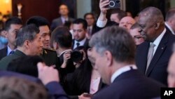 美国国防部长奥斯汀在新加坡出席香格里拉对话期间与中国国防部长李尚福握手。(2023年6月2日)