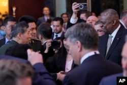 美国防长奥斯汀(右一)与中国防长李尚福(左一)在新加坡的香格里拉对话会议上握手。(2023年6月2日)