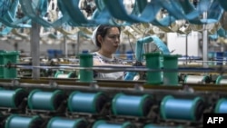 资料照片:中国安徽省阜阳市一名丝绸纺织厂女工在工作。(2024年4月16日)