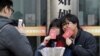一对年轻人在北京一处婚姻登记处外手举结婚证留影。(2017年2月14日)