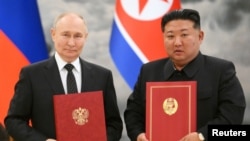 资料照片:俄罗斯总统普京和朝鲜领导人金正恩在朝鲜平壤双边会谈后的协议签字仪式上合影。(2024年6月19日)