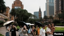 2023 年 4 月 30 日,在中国澳门五一劳动节假期期间,游客在金沙中国运营的伦敦澳门赌场度假村的大本钟复制品前拍照。