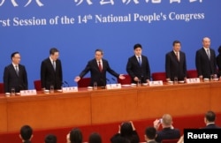 中国总理李强(中)在人大会堂出席记者会。(2023年3月13日)
