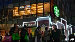 资料照片:2023年12月23日,北京一条商业街上的星巴克咖啡店。(美联社照片)