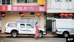 资料照片:2020年2月7日,一名女子在南非约翰内斯堡唐人街散步。(法新社照片)