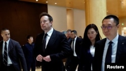 资料照片:特斯拉首席执行官马斯克与特斯拉高管一道离开北京的一家酒店。(2023年5月31日)