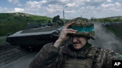 2023年4月26日,一名乌克兰士兵在乌克兰顿涅茨克地区巴赫穆特乘坐装甲运兵车时手拿头盔。(美联社照片)