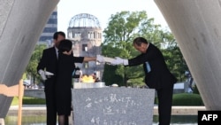 在广岛和平纪念公园举行的仪式上,广岛市长松井一实和死者家属代表将原子弹爆炸遇难者名单安放在纪念碑上。(2023年8月6日)
