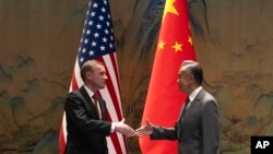中共中央外事工作委员会办公室主任王毅在北京雁栖湖与到访的美国白宫国家安全顾问杰克·沙利文握手。(2024年8月27日)