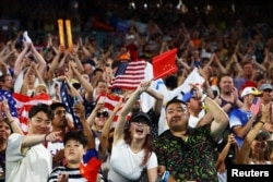 2024巴黎奥运会沙滩女子排球预赛赛场的观众席上,中国和美国球迷为本国球队加油。(2024年8月7日)