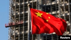 中国国旗在北京一处正在施工的楼盘前飘扬。(2013年11月4日)