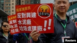 2023年3月26日,在中国香港,抗议者被要求在脖子上系上编号的挂牌,抗议一项填海造地和垃圾转运站项目,这是自颁布全面的国家安全法以来首次获得正式批准的示威活动之一。