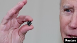 拜登总统在白宫签署有关解决全球半导体芯片短缺的行政令期间手拿芯片发表讲话。(2021年2月24日)