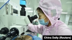中国江苏省宿迁市一家半导体芯片公司的工人在生产线上检查晶圆。(2023年2月28日)