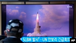 资料照片:2021 年 10 月 20 日,在韩国首尔的首尔火车站中播放的新闻节目中,一名男子正在观看电视屏幕上播放的朝鲜从潜艇发射导弹的画面。