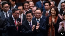 立法会全票通过根据《基本法》第23条订立的新的国家安全法案后,香港特首李家超带领立法会议员鼓掌。(2024年3月19日)(2024年3月19日)