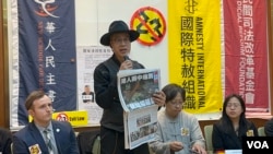 香港流亡艺术家黄国才现场拿出2021年停刊前的最后一期香港《苹果日报》,演示如何轻易违反23条立法。(美国之音 李贤)